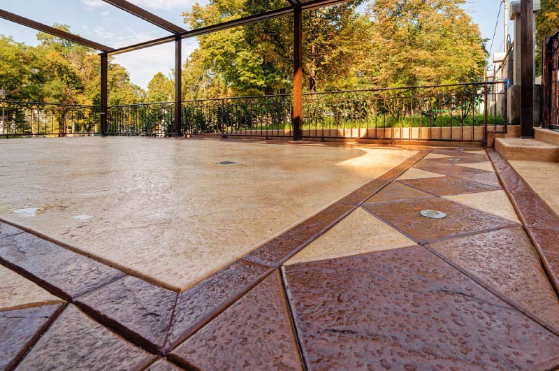 Decorative stamped concrete patio with a two-tone geometric pattern<br />
